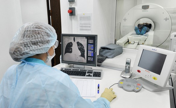 Проведение компьютерной томографии (рентгенолог в маске и перчатках)